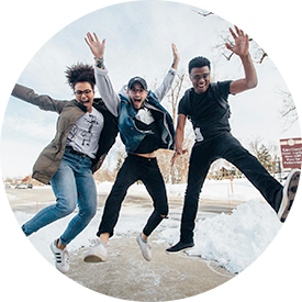 three young adults happily jumping into the air in sync